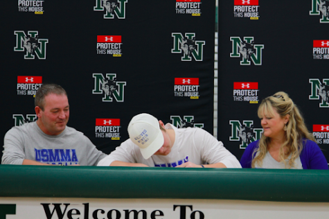 Senior Bo Kemmet signs for college as his mom and dad smile