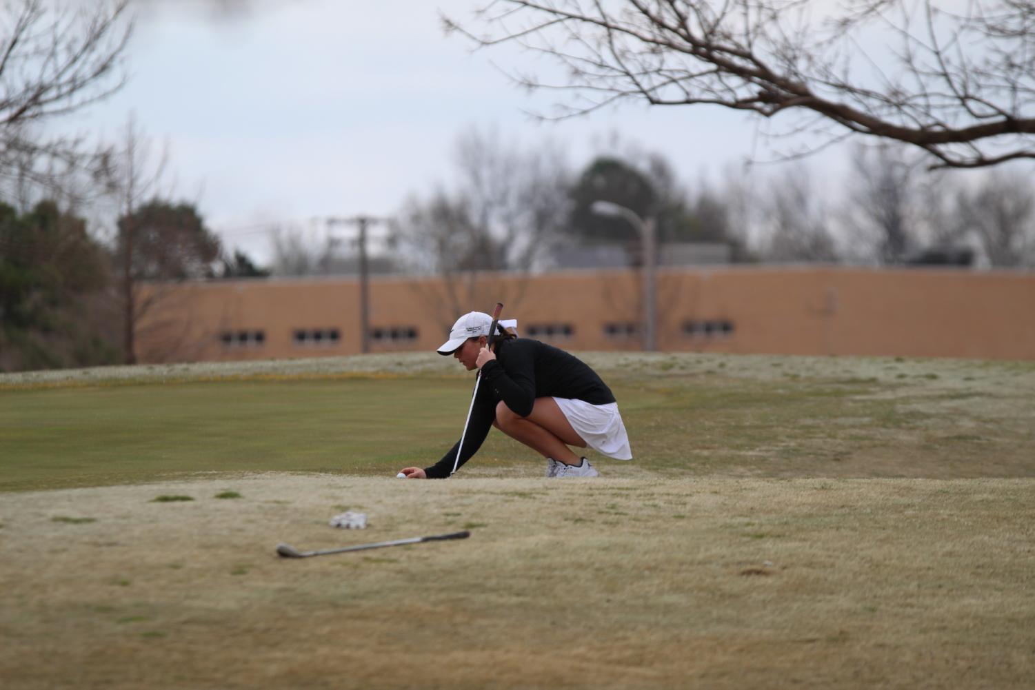 Makenzie Merkley spots the ball just outside the green.