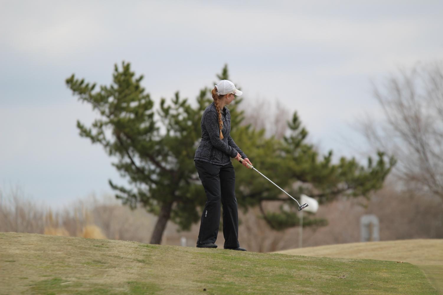 Kenli Divelbiss hits her ball onto the green around hole seven.