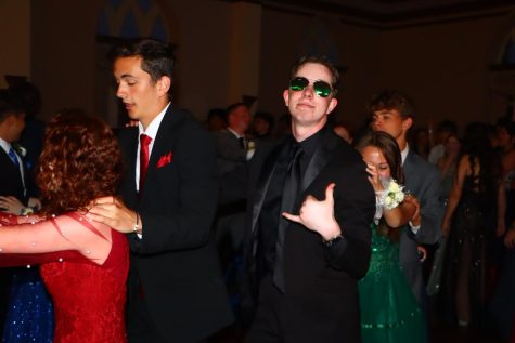 A student poses for a photo in a conga line at prom. 