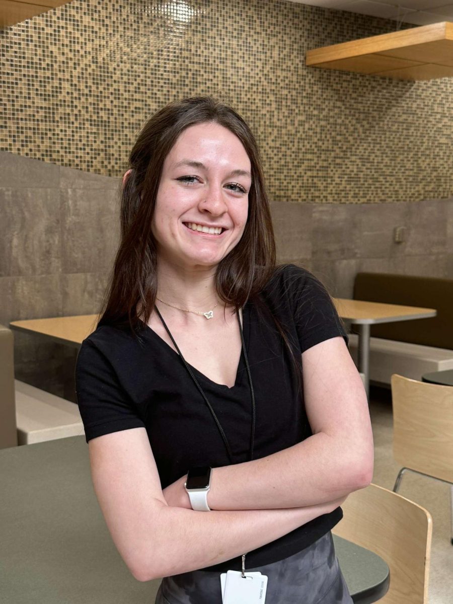 Gracie Bolin looking pleased while waiting to publish pictures in her dress to surprise her peers. 
